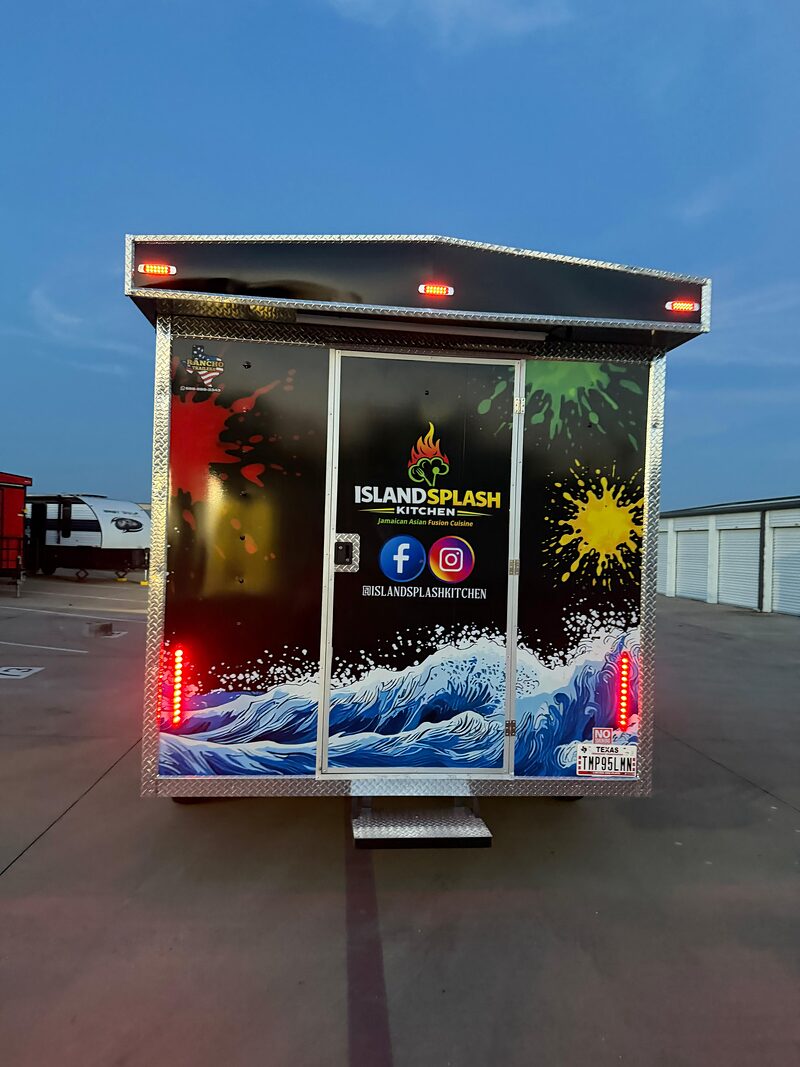 A finished trailer lit up at night, service window open